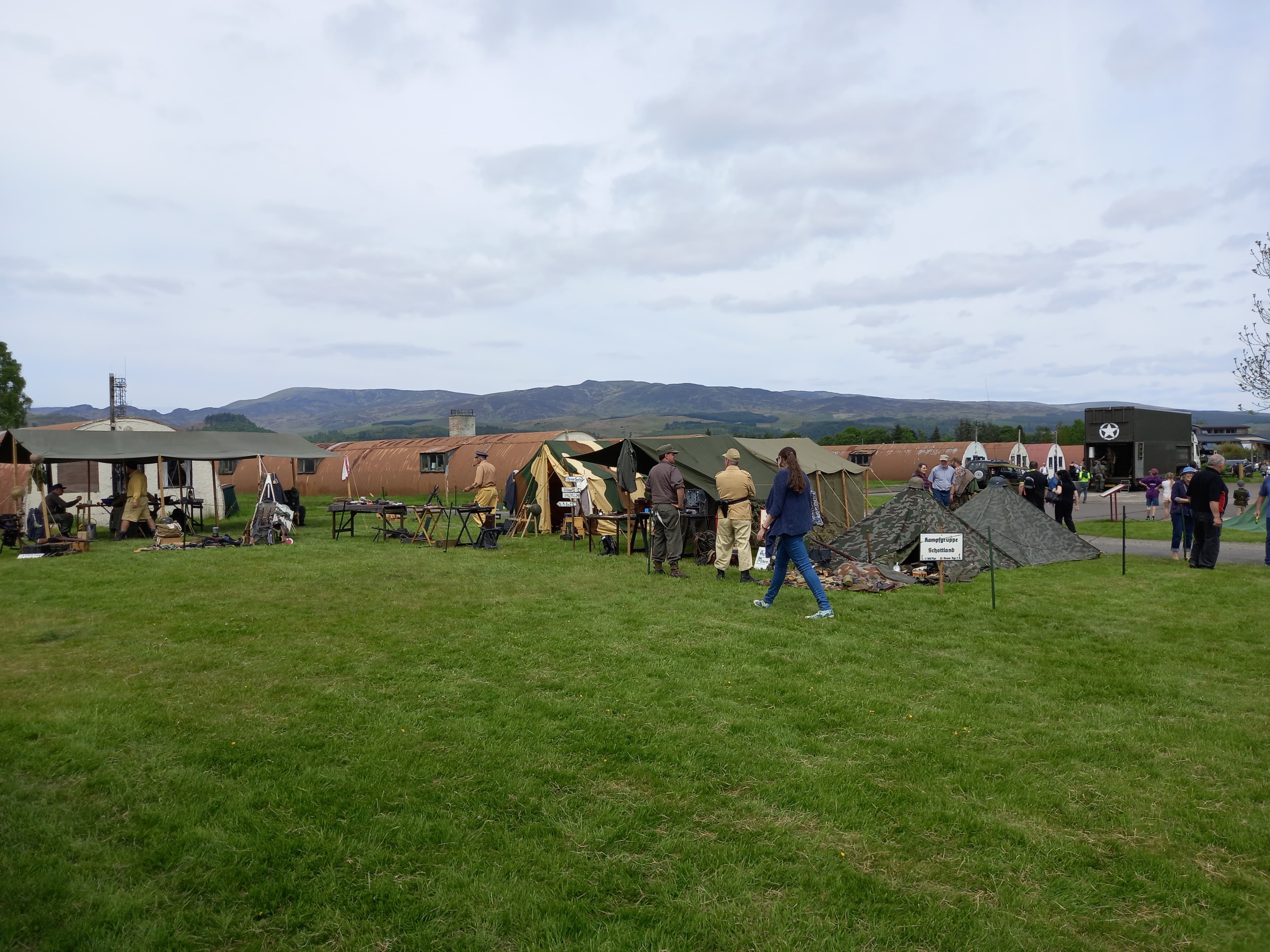 Re-enactment tents, display stalls, visitors, and Nissen huts during an outdoor event at Cultybraggan Camp
