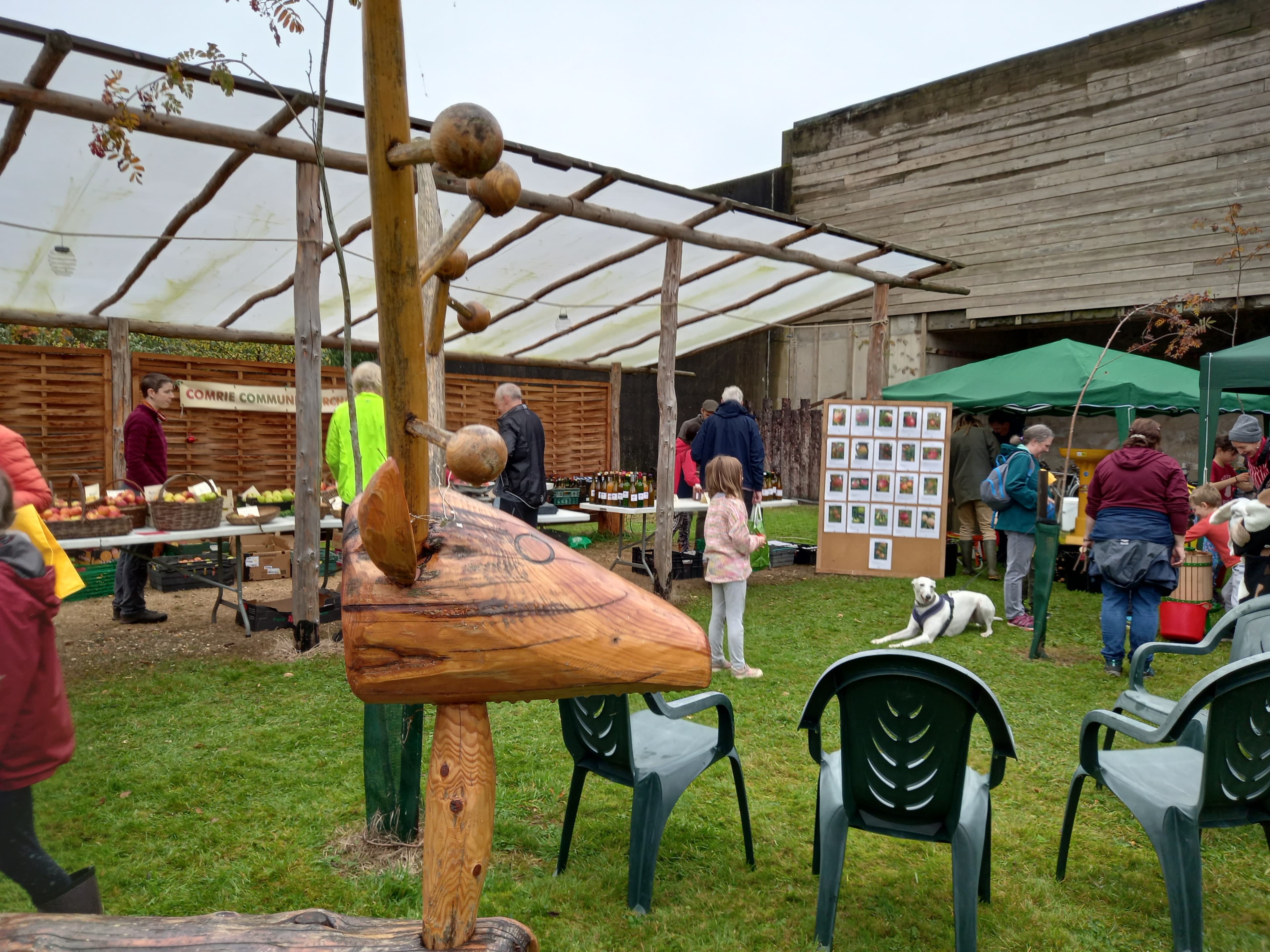 Visitors browsing apples, juice, and stalls at Apple Day in the community orchard at Cultybraggan Camp